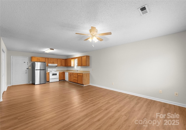 kitchen with sink, white appliances, light hardwood / wood-style floors, and ceiling fan