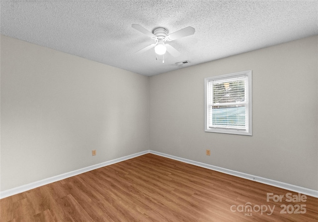 unfurnished room featuring hardwood / wood-style flooring, ceiling fan, and a textured ceiling