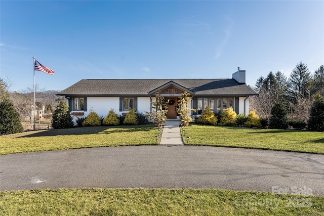 single story home with a front lawn