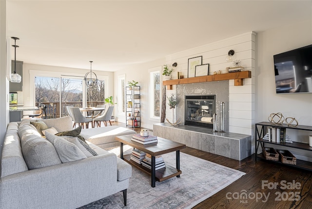 living room featuring dark hardwood / wood-style floors, a tile fireplace, and a wealth of natural light