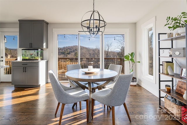 dining room with dark hardwood / wood-style floors and a chandelier