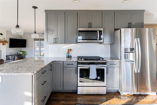 kitchen with light stone counters, kitchen peninsula, and appliances with stainless steel finishes