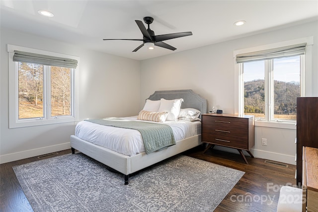 bedroom with dark hardwood / wood-style flooring and ceiling fan