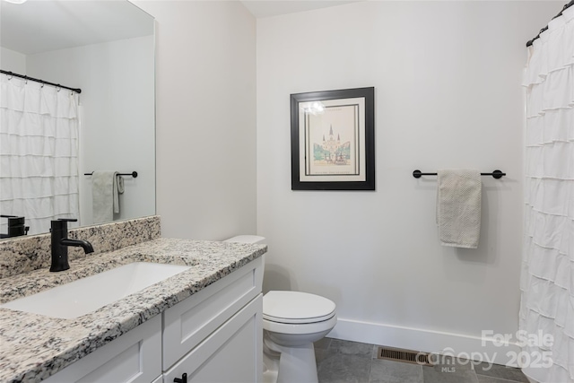 bathroom with vanity, tile patterned floors, and toilet