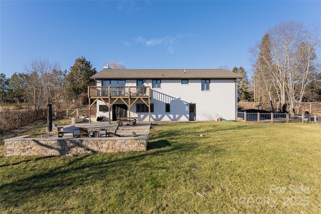 back of house featuring a wooden deck and a lawn