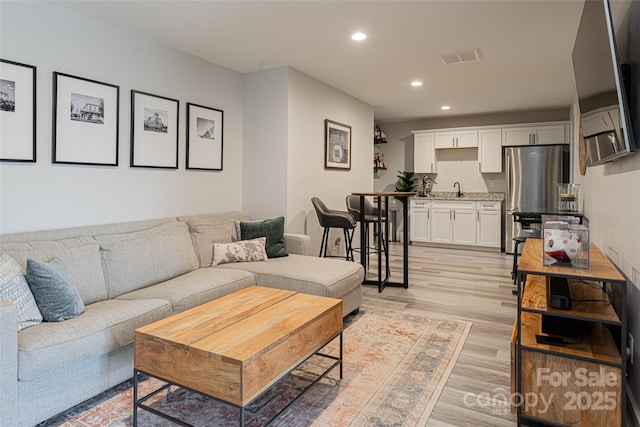 living room with sink and light hardwood / wood-style flooring