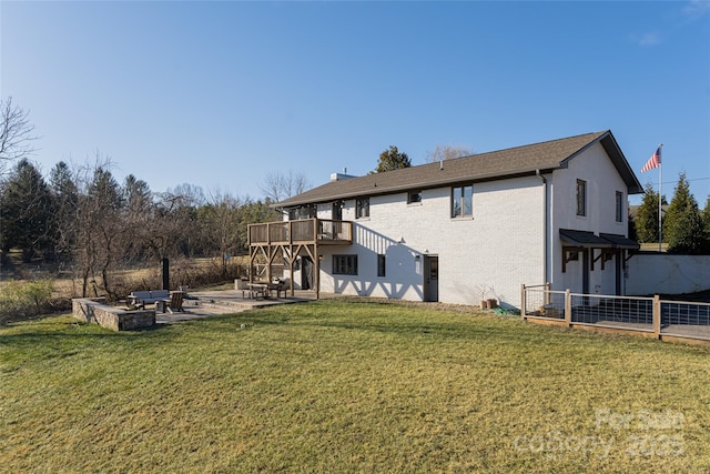 rear view of property with a deck, a patio area, and a lawn