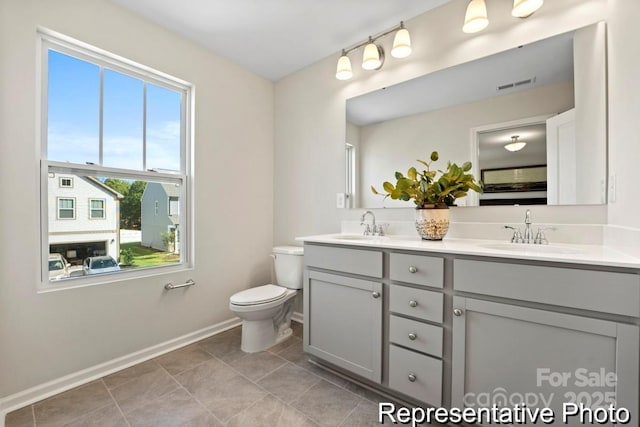 bathroom with vanity, tile patterned flooring, and toilet