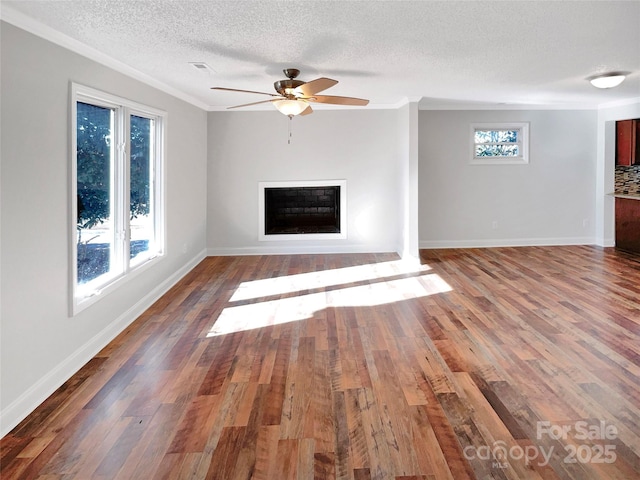 unfurnished living room with crown molding, hardwood / wood-style floors, a textured ceiling, and ceiling fan