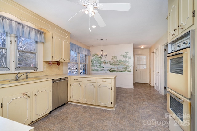 kitchen featuring sink, dishwasher, hanging light fixtures, multiple ovens, and kitchen peninsula