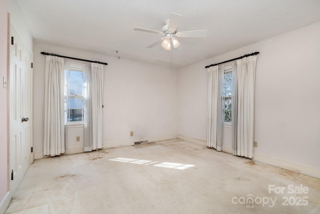 empty room featuring a wealth of natural light and ceiling fan