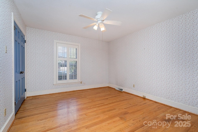 empty room with ceiling fan and wood-type flooring