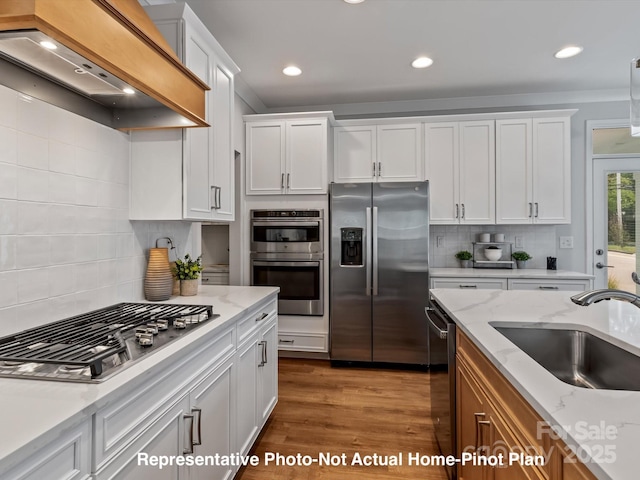 kitchen featuring stainless steel appliances, custom range hood, sink, and white cabinets