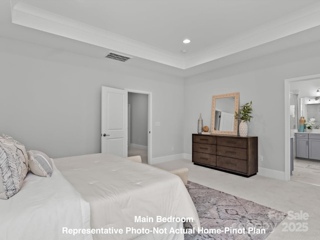 carpeted bedroom with connected bathroom and a tray ceiling