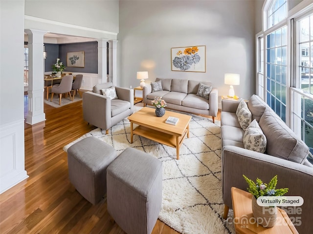 living room with hardwood / wood-style floors and ornate columns