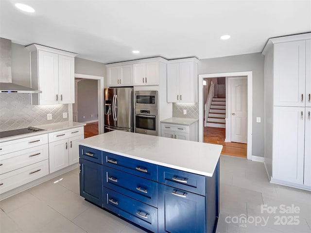 kitchen with blue cabinets, white cabinetry, and stainless steel appliances