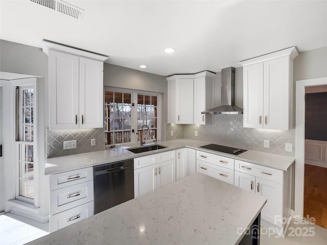 kitchen featuring sink, black appliances, wall chimney range hood, light stone countertops, and white cabinets