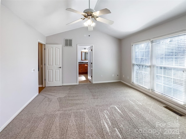 unfurnished bedroom featuring connected bathroom, carpet floors, ceiling fan, and vaulted ceiling