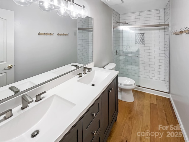 bathroom featuring toilet, hardwood / wood-style floors, vanity, and walk in shower