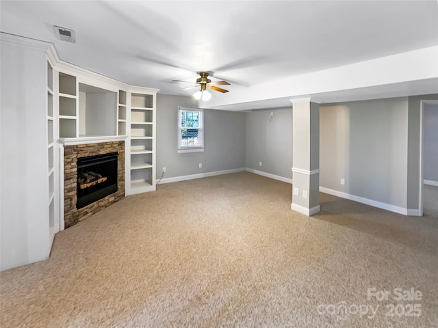 unfurnished living room with ceiling fan, carpet flooring, and a stone fireplace