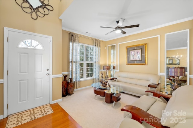 living room featuring crown molding, wood-type flooring, and ceiling fan with notable chandelier