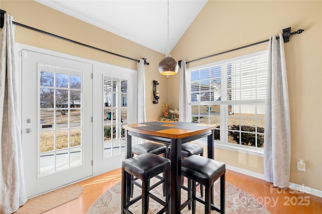 dining space with lofted ceiling and light hardwood / wood-style flooring