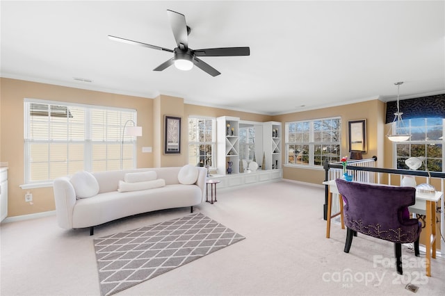 carpeted living room featuring ornamental molding and ceiling fan