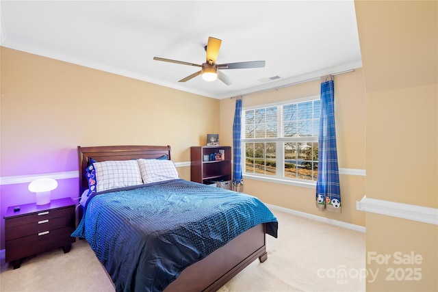 carpeted bedroom with ornamental molding and ceiling fan