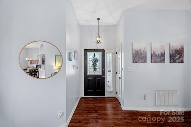 foyer featuring dark hardwood / wood-style flooring and a chandelier