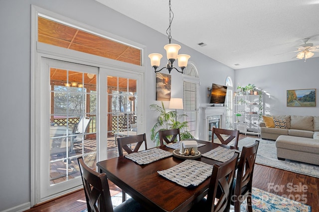 dining space featuring dark hardwood / wood-style floors and ceiling fan with notable chandelier