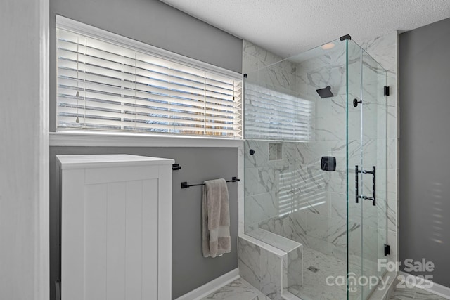 bathroom with an enclosed shower and a textured ceiling