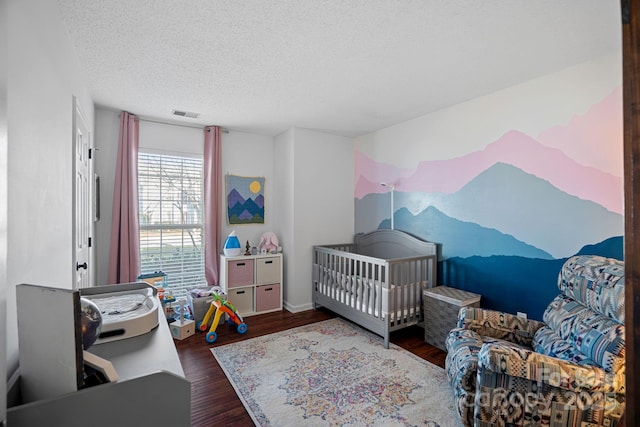 bedroom with dark hardwood / wood-style floors and a textured ceiling