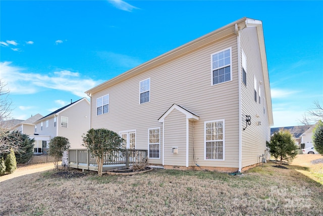 back of house with a wooden deck and a lawn