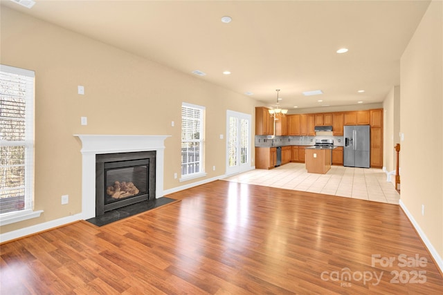 unfurnished living room featuring light hardwood / wood-style flooring and a notable chandelier