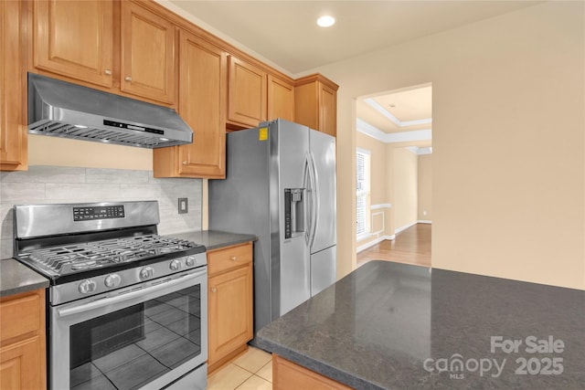 kitchen with a tray ceiling, light tile patterned floors, decorative backsplash, and stainless steel appliances