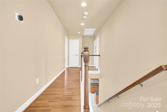 hallway featuring a skylight and light wood-type flooring