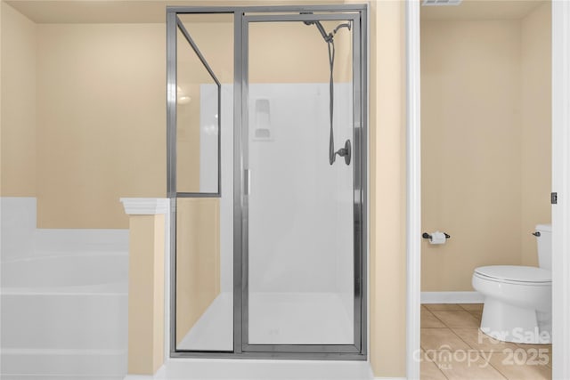 bathroom featuring toilet, independent shower and bath, and tile patterned flooring