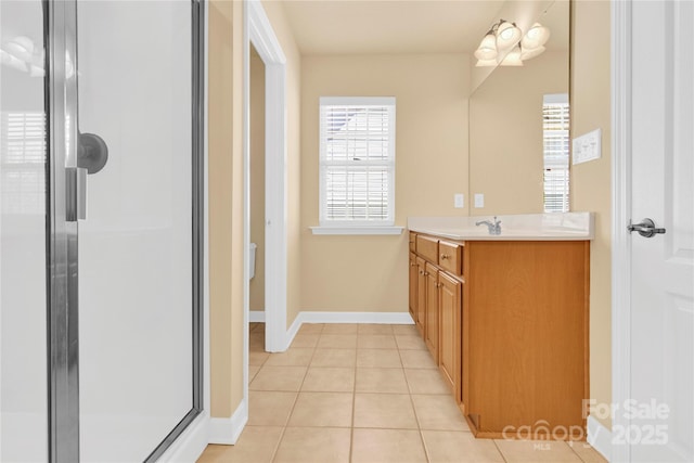 bathroom with tile patterned floors, a shower with door, and vanity