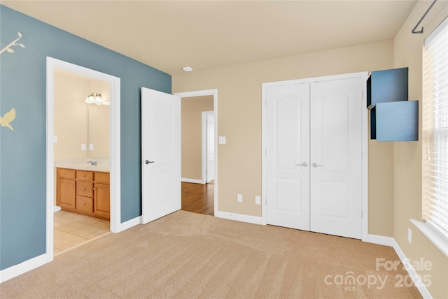 unfurnished bedroom with multiple windows, a closet, sink, and light carpet