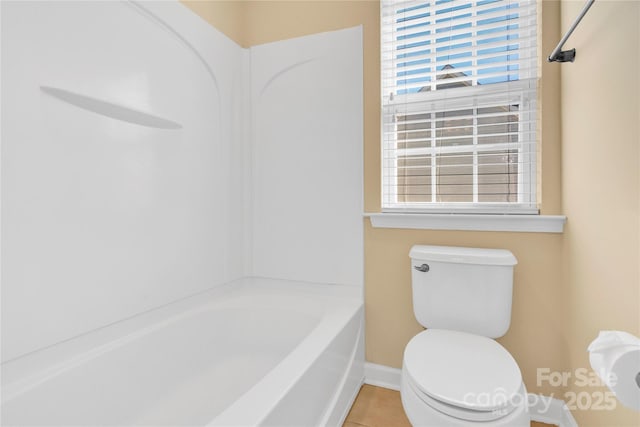 bathroom featuring tile patterned floors, toilet, and a wealth of natural light