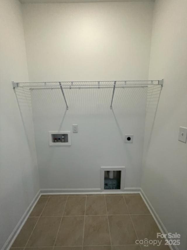 washroom featuring dark tile patterned flooring, hookup for a washing machine, and electric dryer hookup