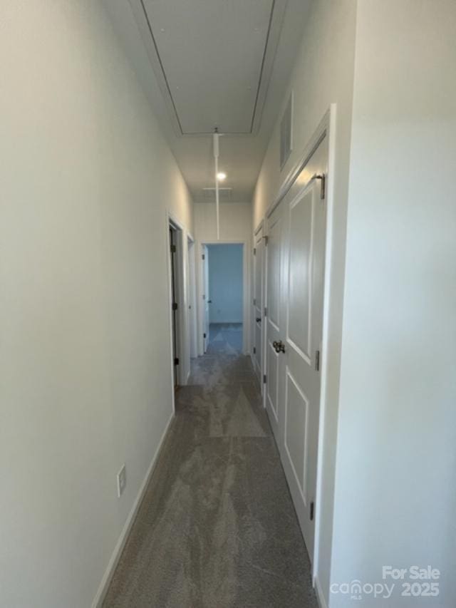 hallway featuring dark colored carpet