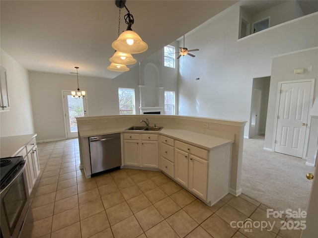 kitchen featuring sink, decorative light fixtures, light colored carpet, stainless steel appliances, and white cabinets