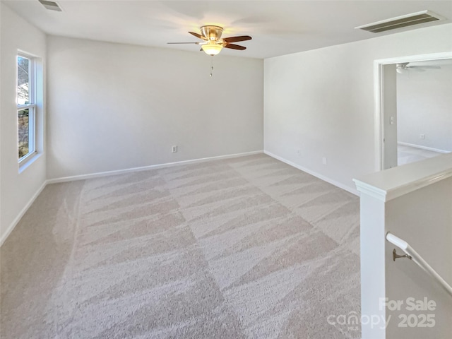 spare room with light colored carpet and ceiling fan