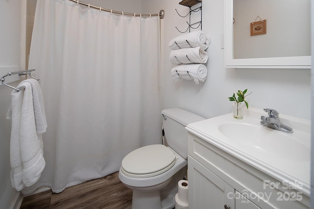 bathroom with toilet, vanity, and hardwood / wood-style floors