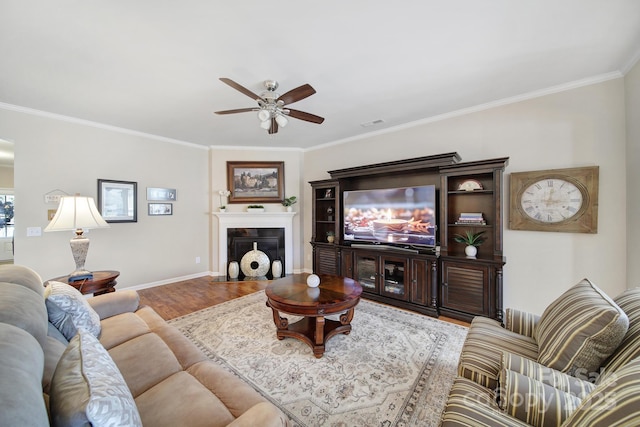 living room featuring ornamental molding, hardwood / wood-style floors, and ceiling fan