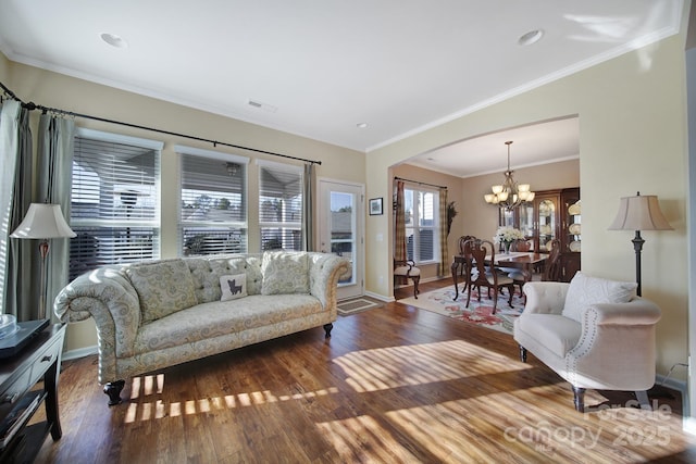 living room featuring crown molding, wood-type flooring, and a notable chandelier