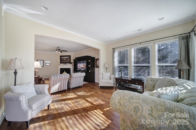 living room with crown molding, hardwood / wood-style floors, and ceiling fan