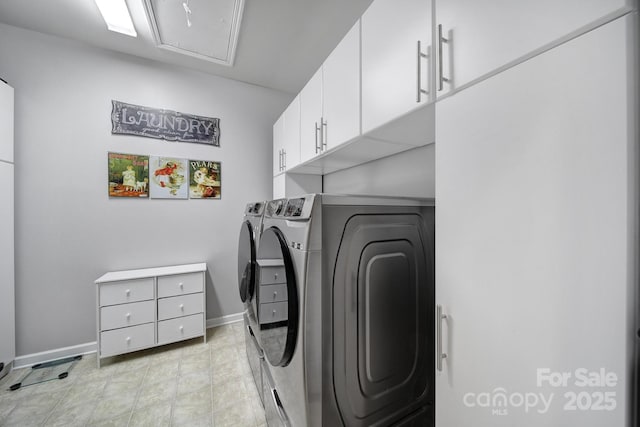 laundry area featuring separate washer and dryer and cabinets