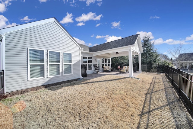 rear view of house featuring ceiling fan, a yard, and a patio area